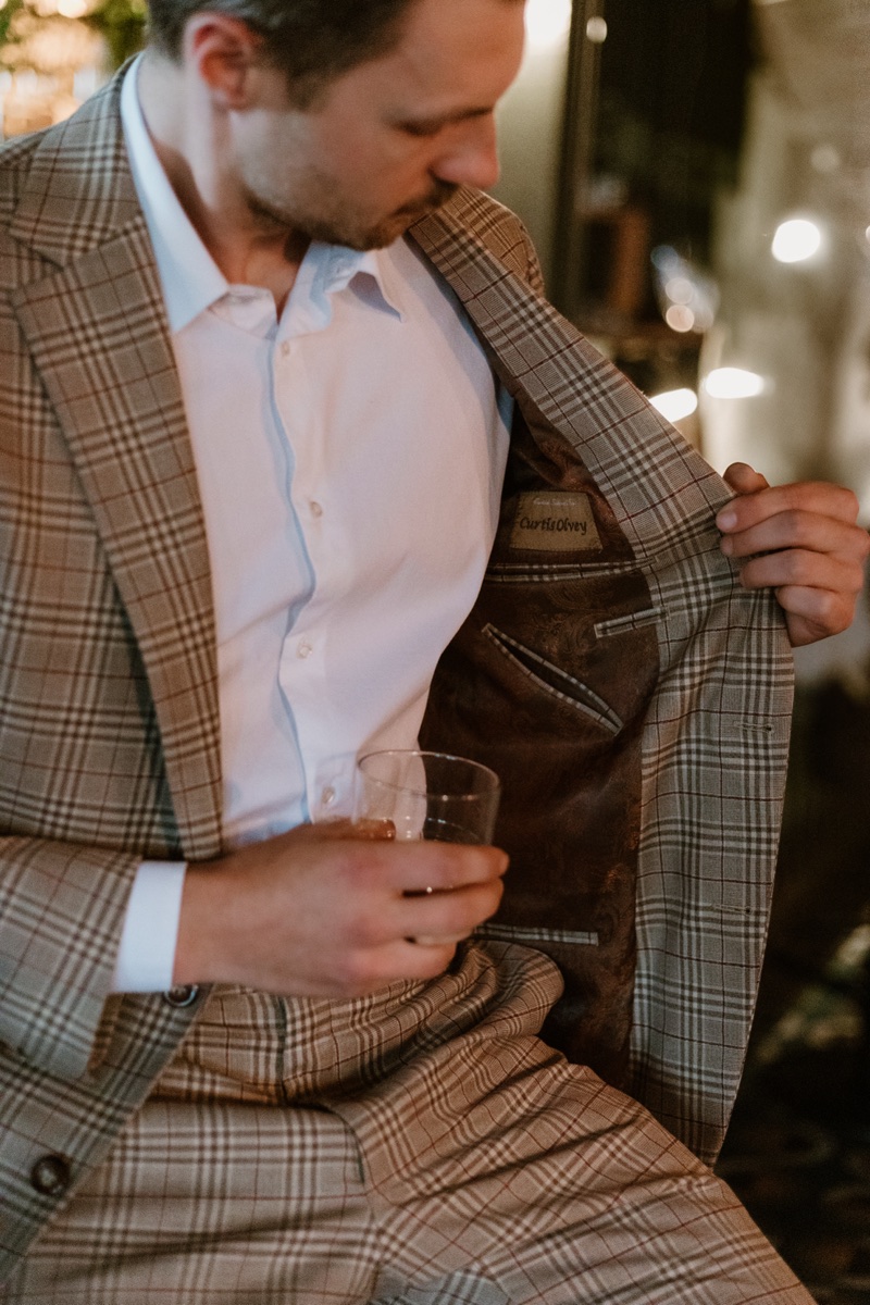 Curtis Olvey Jr. holding open a custom jacket to show the lining, embroidered with his name